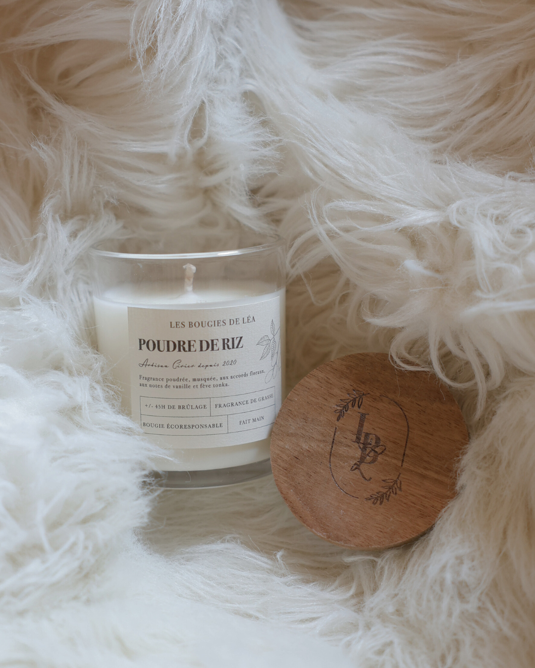 Bougie parfumée artisanale Poudre de Riz Les Bougies de Léa sur un tissus en laine blanc pour une ambiance chaleureuse et cocooning.