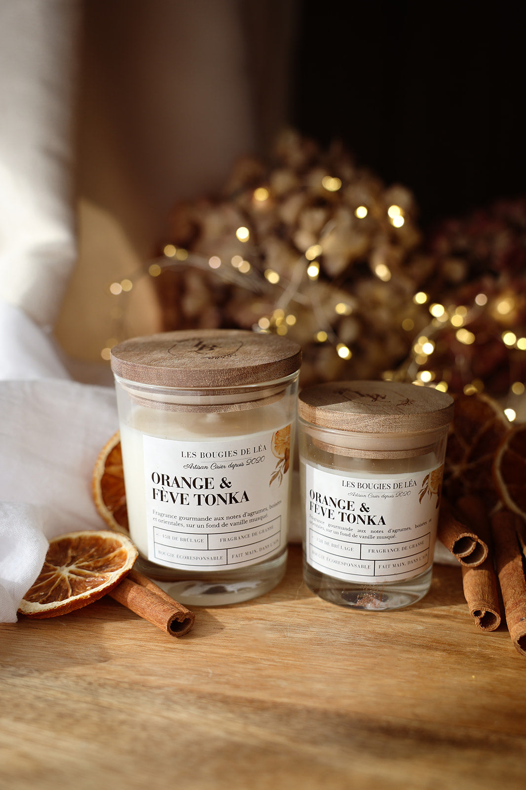 Bougies artisanales parfumées Orange et fève Tonka, orange cannelle avec couvercles en bois d'acacia, avec déco orange séchée, bâton de cannelle et guirlande lumineuse.