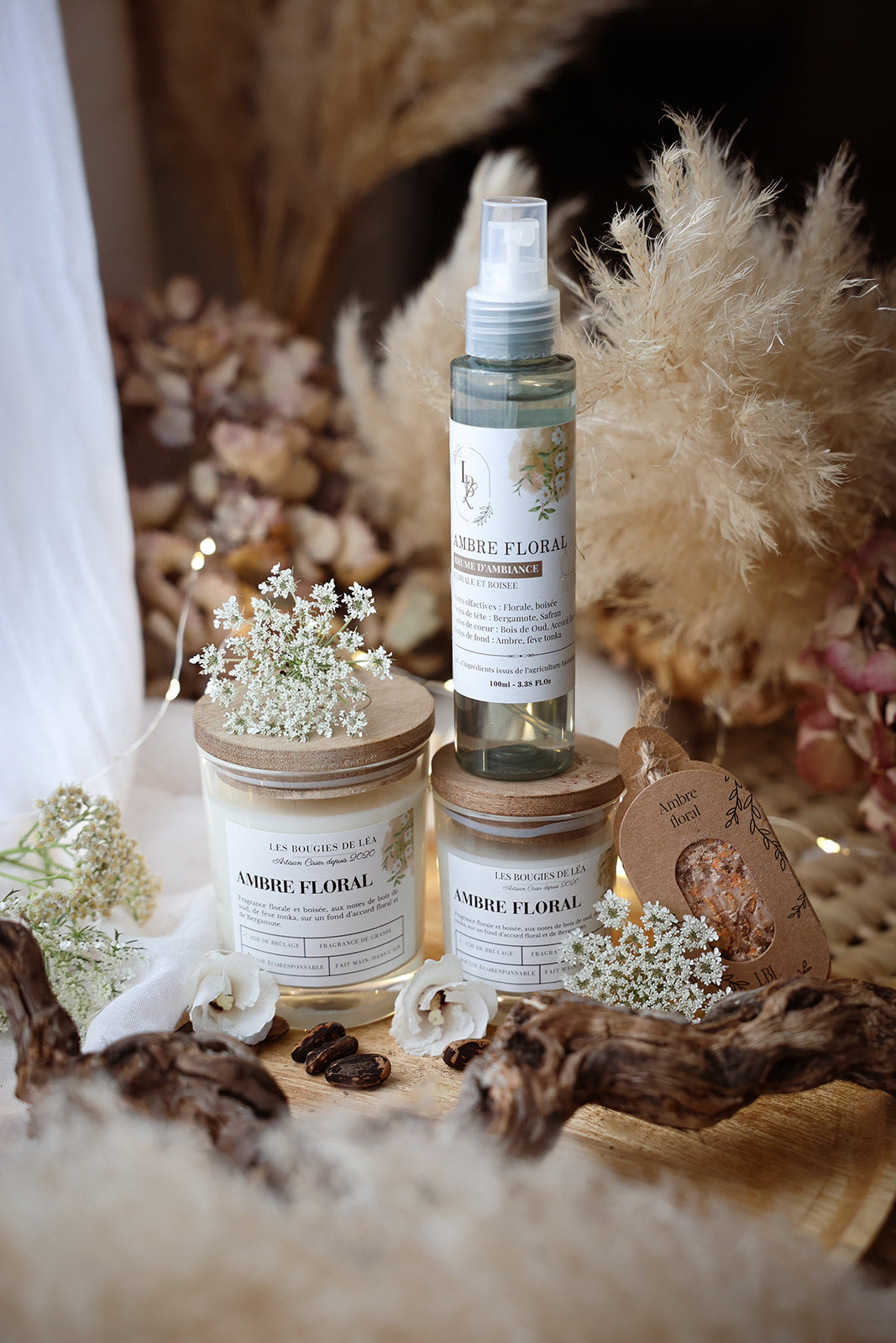 Brume d'ambiance végétale et parfumée LBL Ambre Floral Bois de Oud sur une table en bois dans une déco bohème chic avec fleurs blanches et bois
