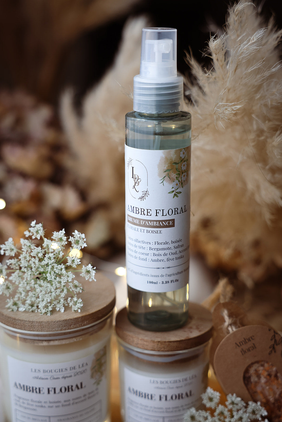 Brume d'ambiance végétale et parfumée LBL Ambre Floral Bois de Oud sur une table en bois dans une déco bohème chic avec fleurs blanches et bois