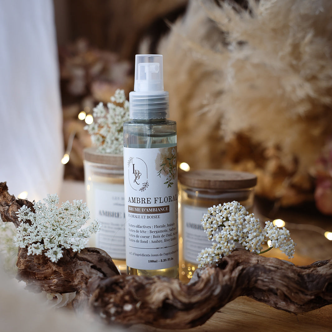 Brume d'ambiance végétale et parfumée LBL Ambre Floral Bois de Oud sur une table en bois dans une déco bohème chic avec fleurs blanches et bois