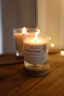 Bougie artisanale parfumée Ambre Floral Les Bougies de Léa allumée sur meuble en bois comme objet de décoration d'intérieur