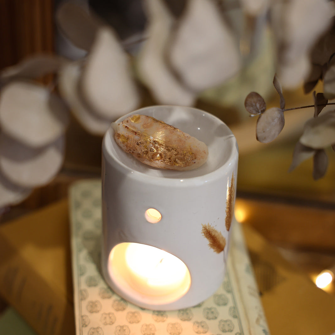 Fondant parfumé LBL Ambre Floral, Santal, Bois de Oud sur brûle-parfum en céramique et bougie chauffe plat allumée, comme objet de déco chaleureux