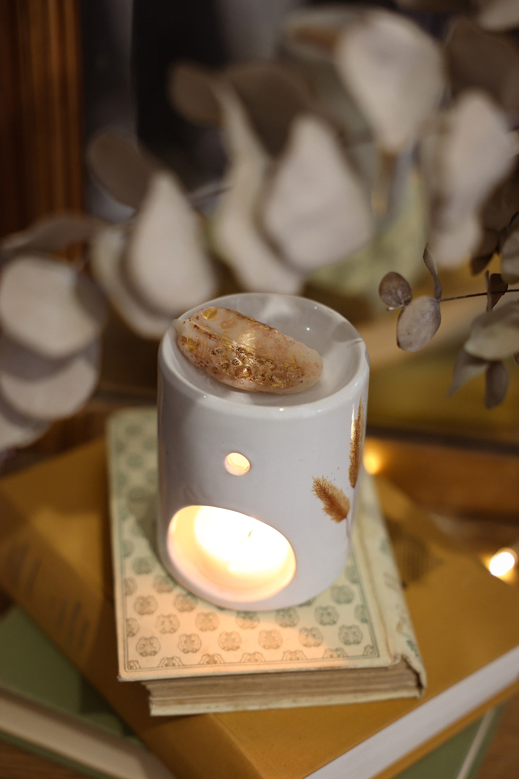 Fondant parfumé LBL Ambre Floral, Santal, Bois de Oud sur brûle-parfum en céramique et bougie chauffe plat allumée, comme objet de déco chaleureux