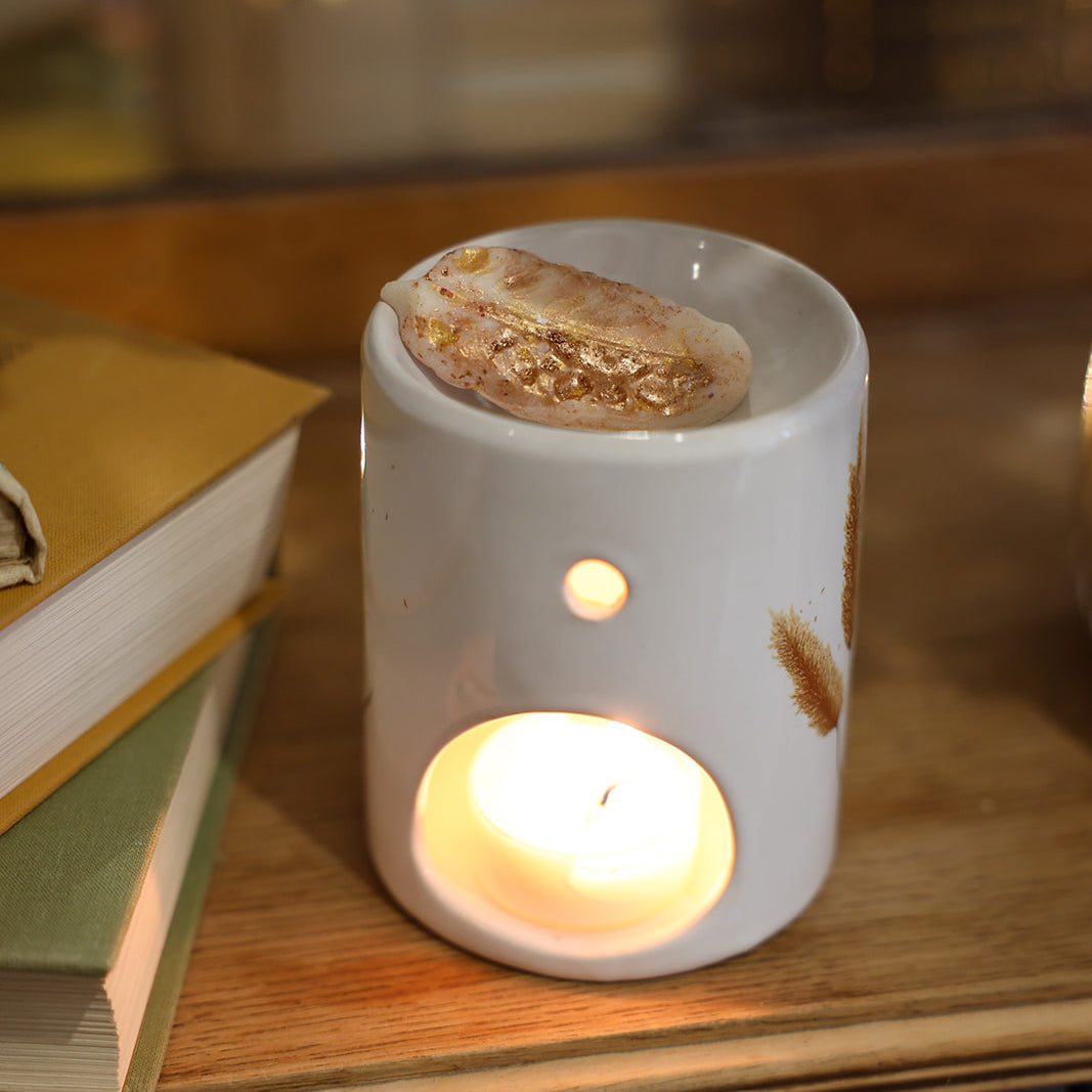 Fondant parfumé LBL Ambre Floral, Santal, Bois de Oud sur brûle-parfum en céramique et bougie chauffe plat allumée, comme objet de déco chaleureux