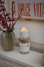 Bougies artisanales parfumées Les Bougies de Léa Pêche de vigne, sur une cheminée bohème chic, accompagnées d'un vase de Fleurs de Cerisier et un table au mur "Dolce Vita" terracotta.