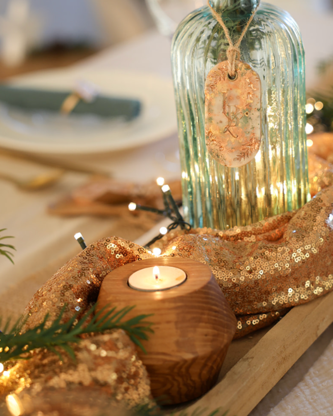 Gros plan sur le grain du bois de frêne du bougeoir artisanal avec une bougie allumée, décoration et ambiance Noël.