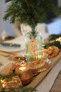 Gros plan sur le grain du bois de frêne du bougeoir artisanal fait main en France, région lyonnaise avec une bougie allumée, décoration et ambiance Noël.